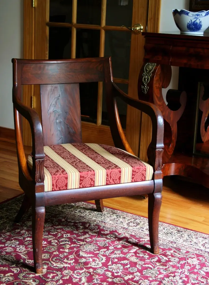 Ancient fauteuil avec un tissu rayé.